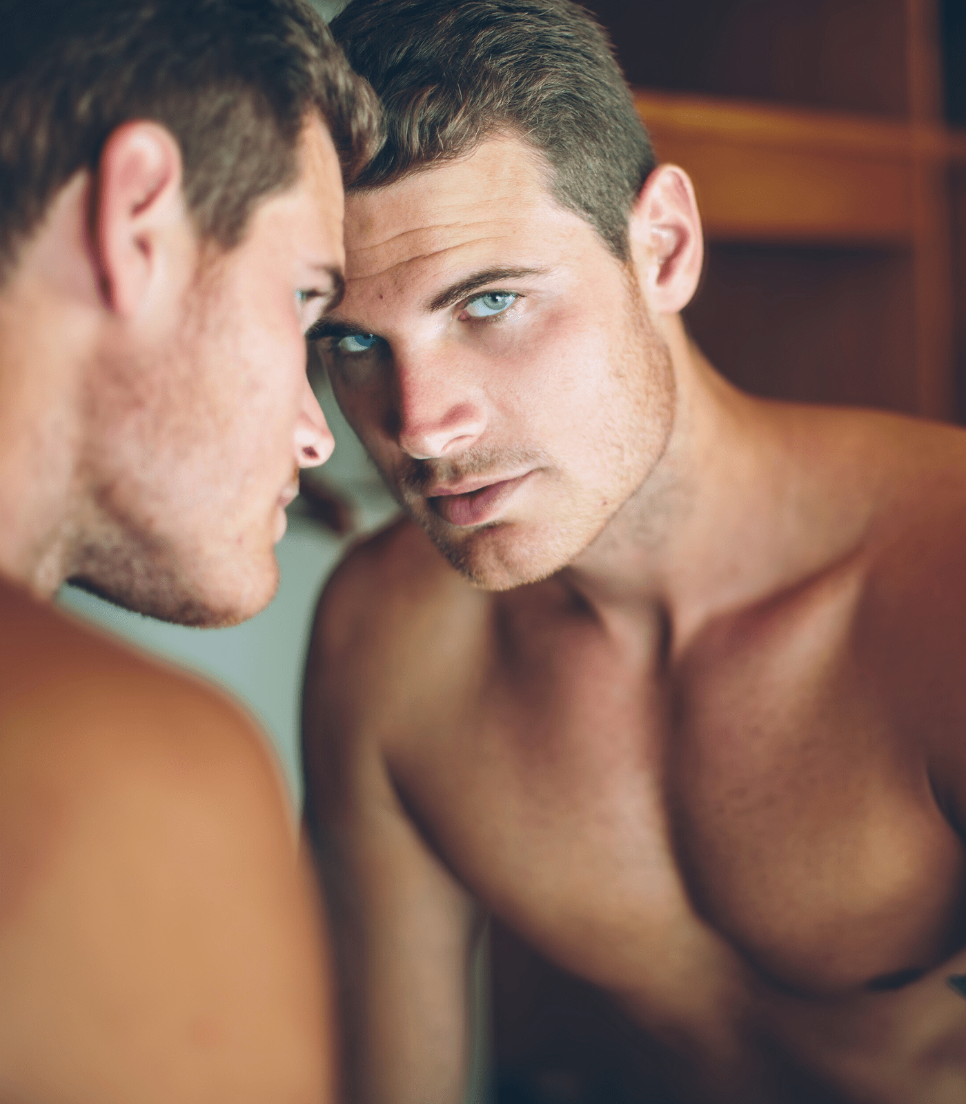 handsome young man looking in mirror